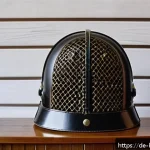 검도 장비 중고 구매 가이드 - A close-up image of a used Kendo Men helmet displayed on a wooden surface, showing detailed craftsma...